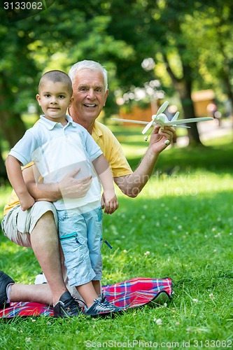 Image of grandfather and child have fun  in park