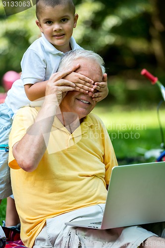 Image of grandfather and child using laptop