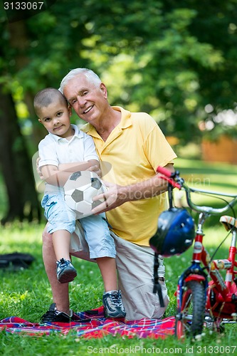 Image of grandfather and child have fun  in park