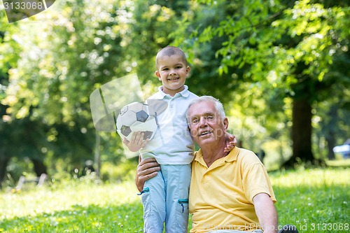 Image of grandfather and child have fun  in park