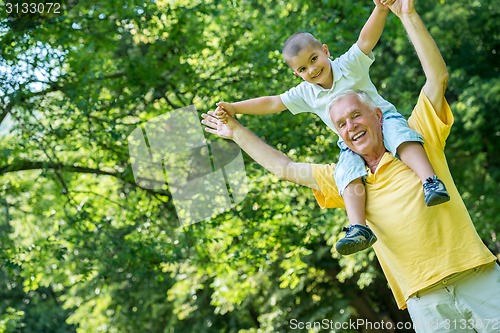 Image of grandfather and child have fun  in park