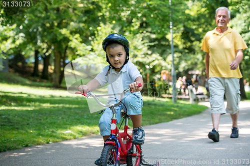 Image of grandfather and child have fun  in park