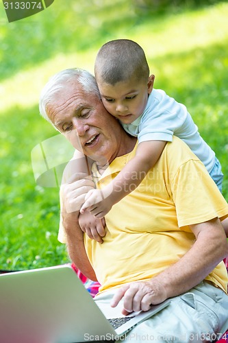 Image of grandfather and child using laptop