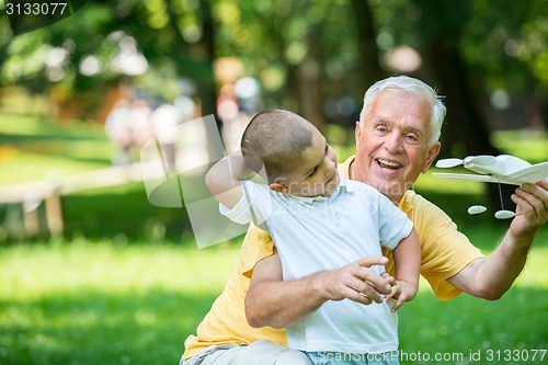 Image of grandfather and child have fun  in park