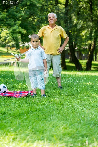 Image of grandfather and child have fun  in park