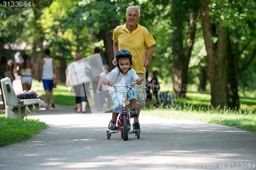 Image of grandfather and child have fun  in park