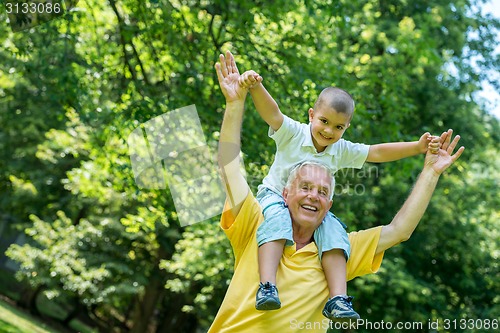 Image of grandfather and child have fun  in park