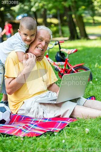 Image of grandfather and child using laptop