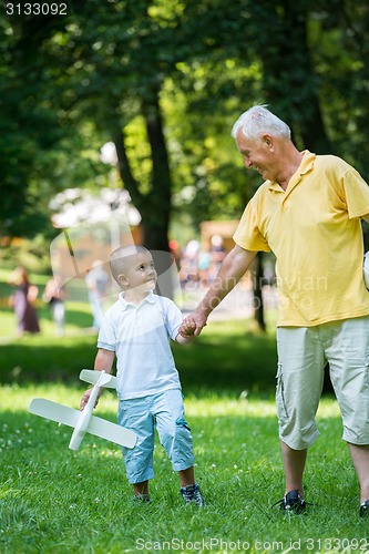 Image of grandfather and child have fun  in park