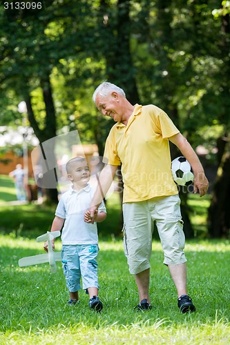 Image of grandfather and child have fun  in park