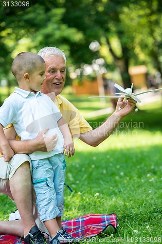 Image of grandfather and child have fun  in park