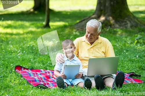 Image of grandfather and child using laptop