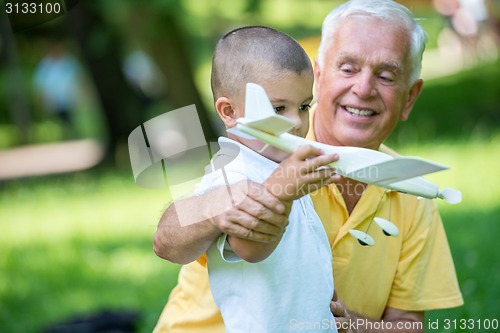 Image of grandfather and child have fun  in park