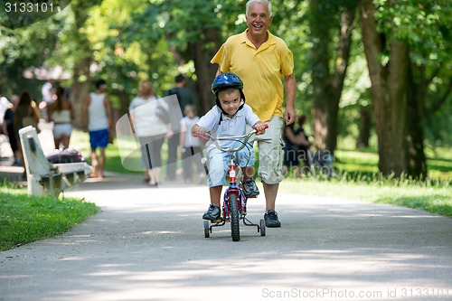 Image of grandfather and child have fun  in park