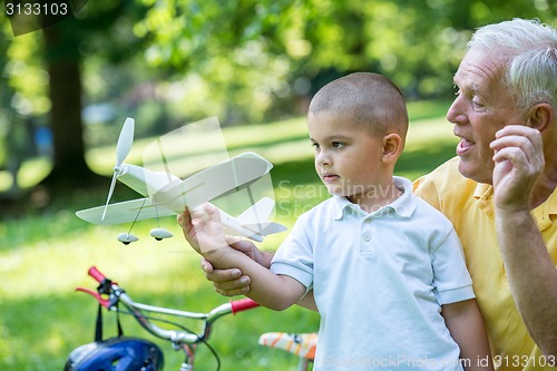 Image of grandfather and child have fun  in park