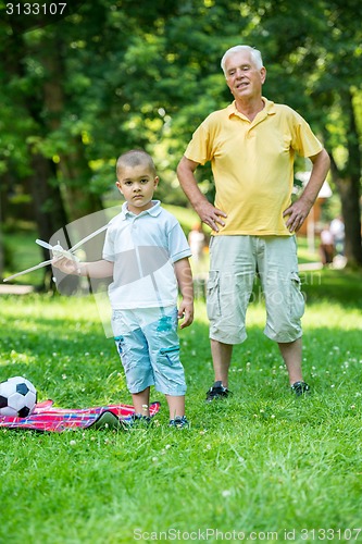 Image of grandfather and child have fun  in park