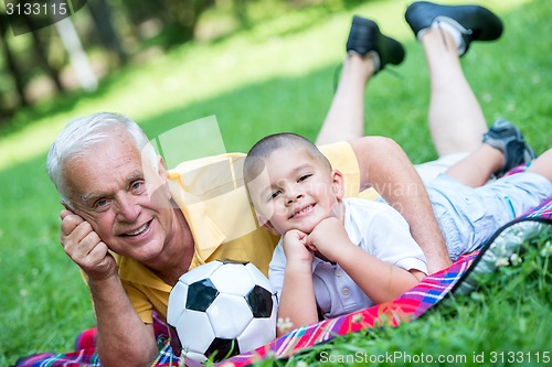 Image of grandfather and child have fun  in park