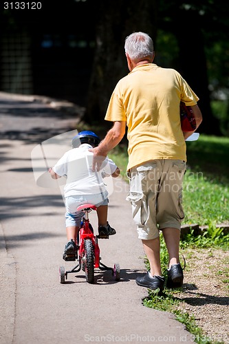 Image of grandfather and child have fun  in park