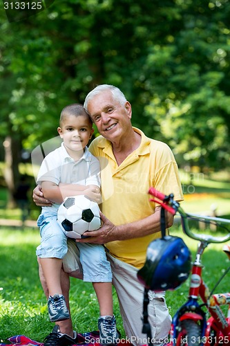 Image of grandfather and child have fun  in park