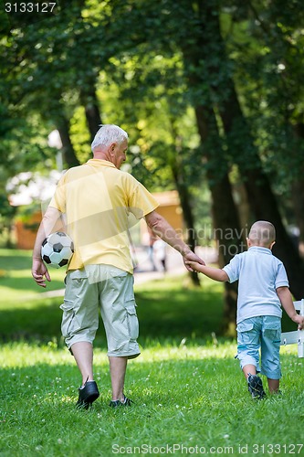 Image of grandfather and child have fun  in park