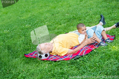 Image of grandfather and child have fun  in park