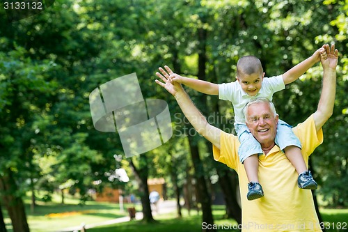 Image of grandfather and child have fun  in park