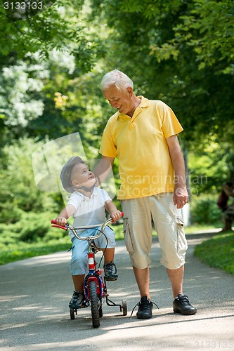 Image of grandfather and child have fun  in park