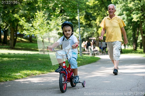 Image of grandfather and child have fun  in park