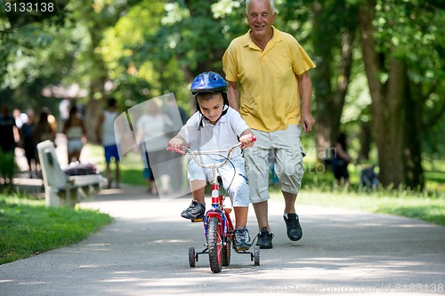 Image of grandfather and child have fun  in park