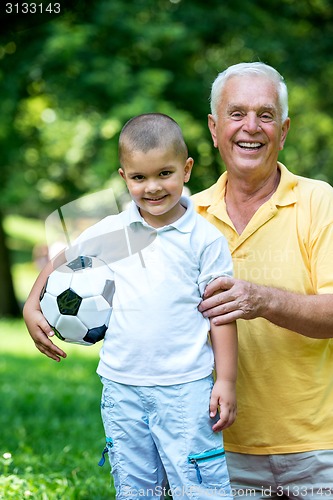 Image of grandfather and child have fun  in park