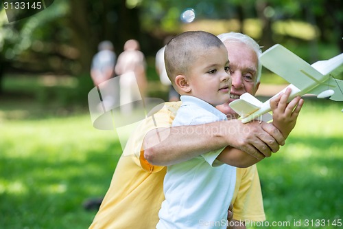 Image of grandfather and child have fun  in park