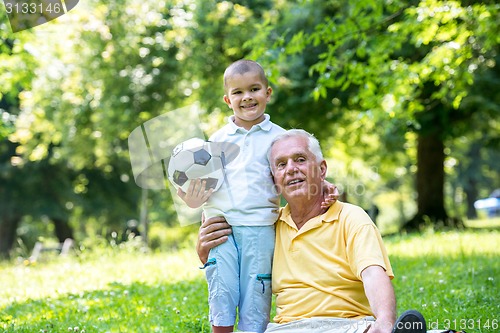 Image of grandfather and child have fun  in park