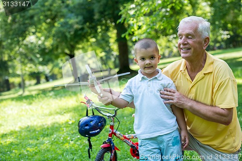 Image of grandfather and child have fun  in park