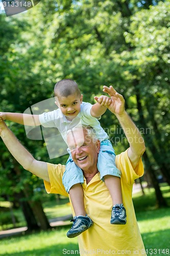 Image of grandfather and child have fun  in park