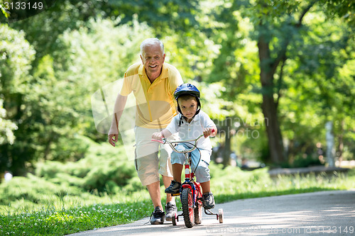 Image of grandfather and child have fun  in park