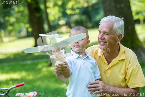 Image of grandfather and child have fun  in park