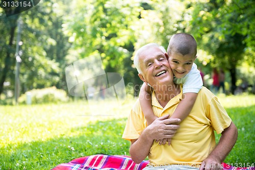 Image of grandfather and child have fun  in park