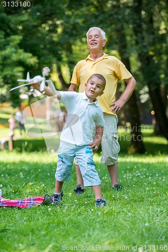 Image of grandfather and child have fun  in park