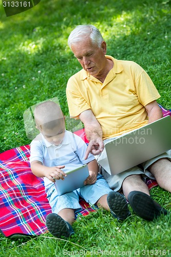 Image of grandfather and child using laptop