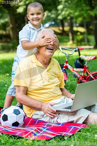 Image of grandfather and child using laptop