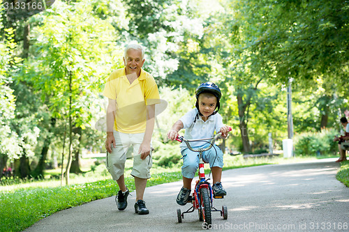 Image of grandfather and child have fun  in park