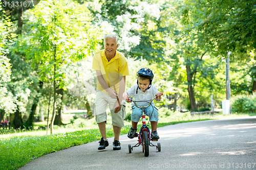 Image of grandfather and child have fun  in park