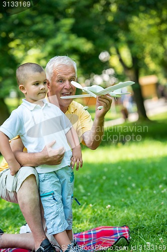 Image of grandfather and child have fun  in park