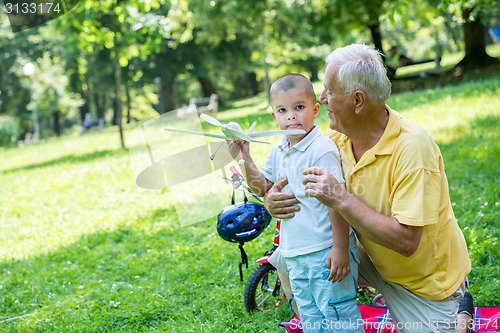 Image of grandfather and child have fun  in park