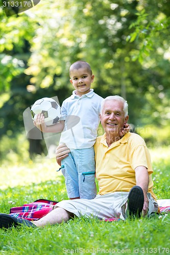 Image of grandfather and child have fun  in park