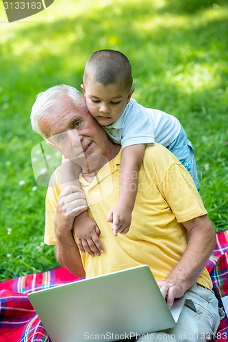 Image of grandfather and child using laptop