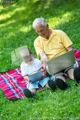 Image of grandfather and child using laptop