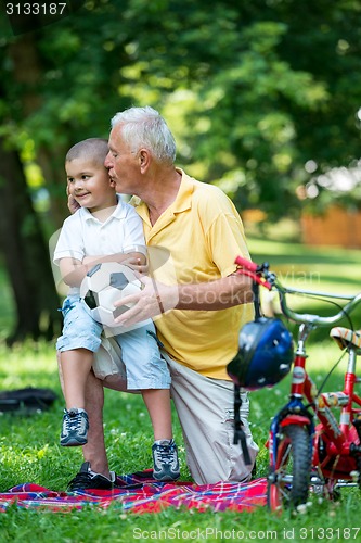 Image of grandfather and child have fun  in park