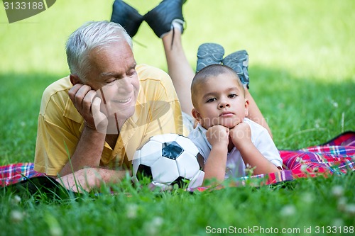 Image of grandfather and child have fun  in park