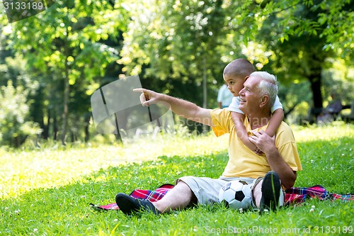 Image of grandfather and child have fun  in park